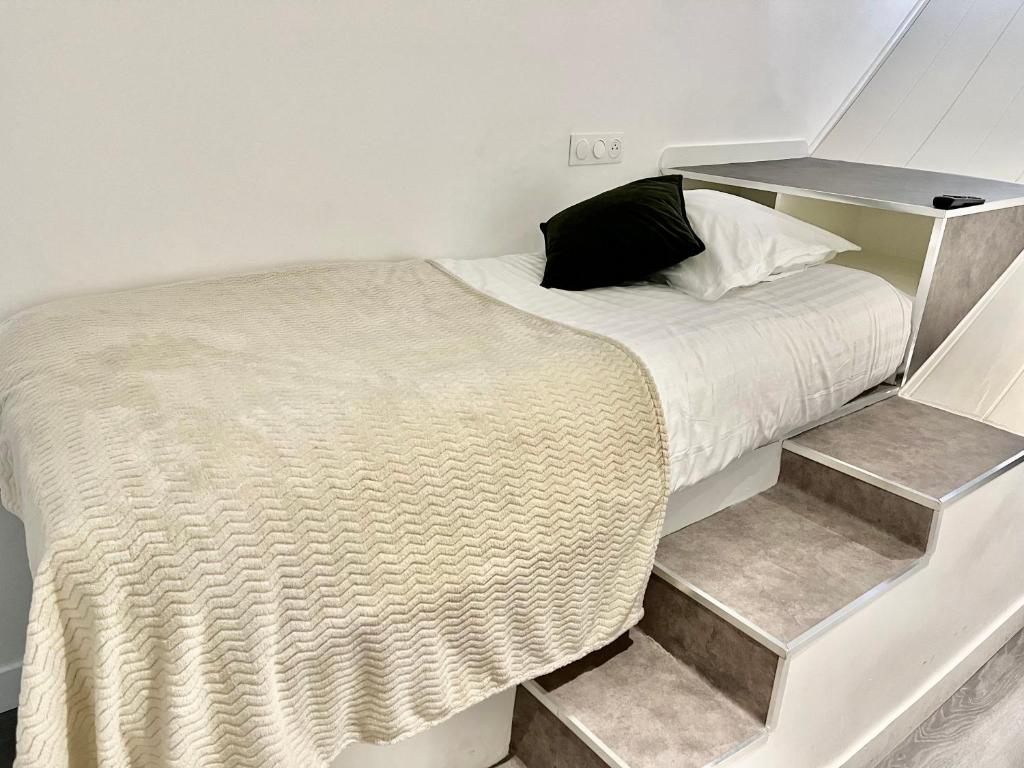 a bedroom with a bed with stairs leading to it at L&#39;Oasis Montparnasse in Paris