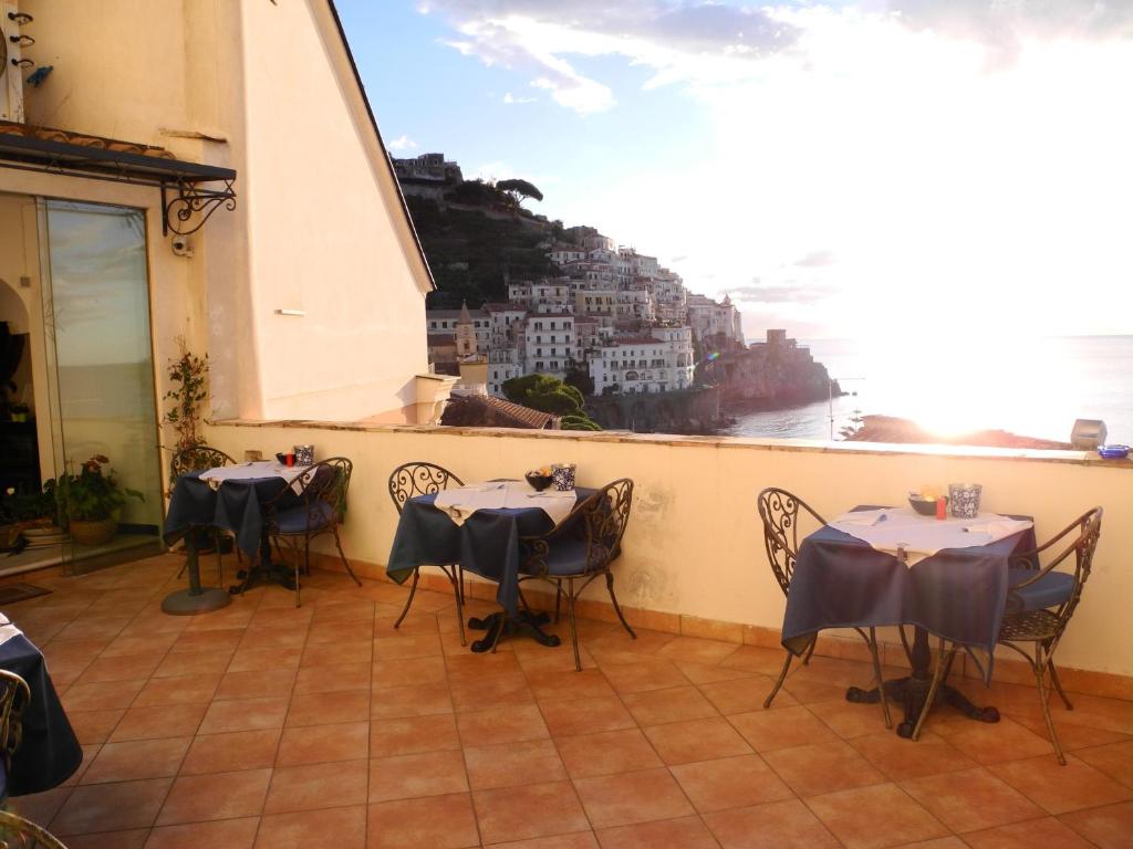 a restaurant with tables and chairs with a view of the ocean at Hotel Croce Di Amalfi in Amalfi