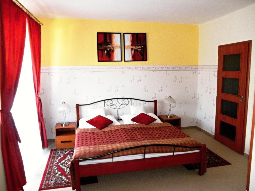 una camera da letto con un letto con cuscini rossi di Hotel Vysocina a Chotěboř