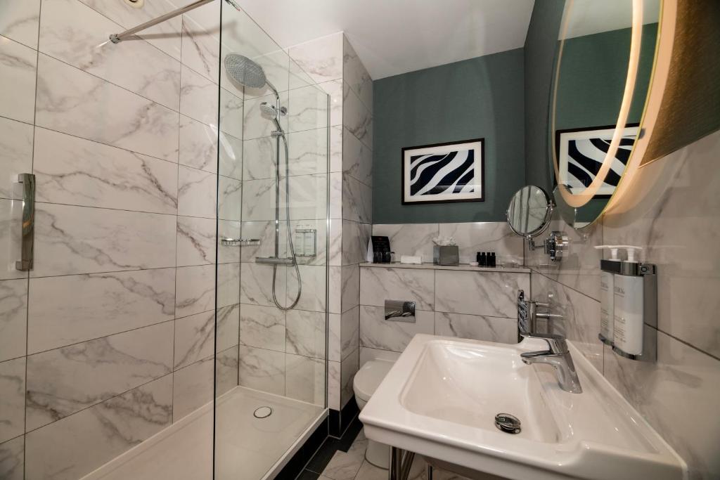 a bathroom with a shower and a sink at Leonardo Royal Hotel Birmingham in Birmingham