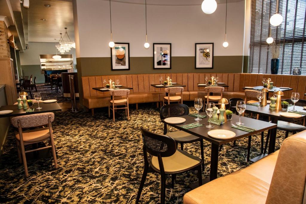 a restaurant dining room with tables and chairs at Leonardo Royal Hotel Birmingham in Birmingham