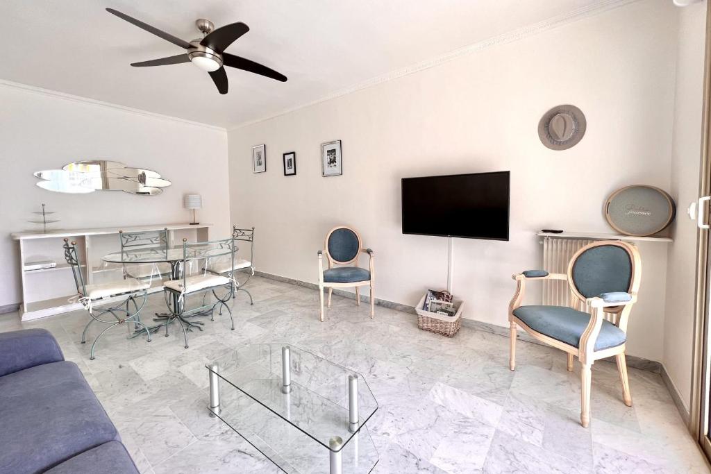 un salon avec un canapé, une table et des chaises dans l'établissement Spacious & refined apt with large terrace Wifi, à Cannes