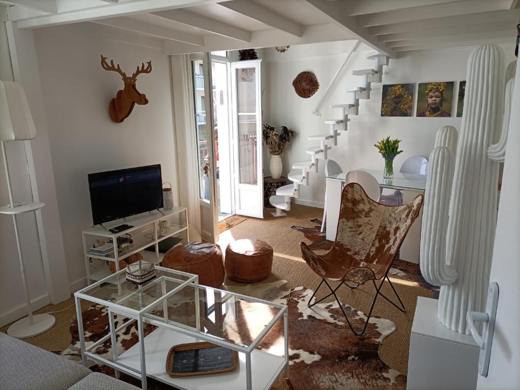 un salon avec un escalier et une télévision dans l'établissement Résidence de Charme TIVOLI, à Arcachon