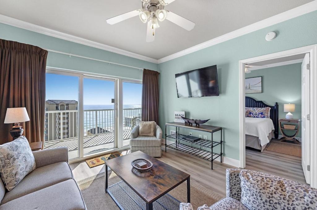 a living room with a couch and a room with a balcony at Crystal Tower Unit 908 in Gulf Shores