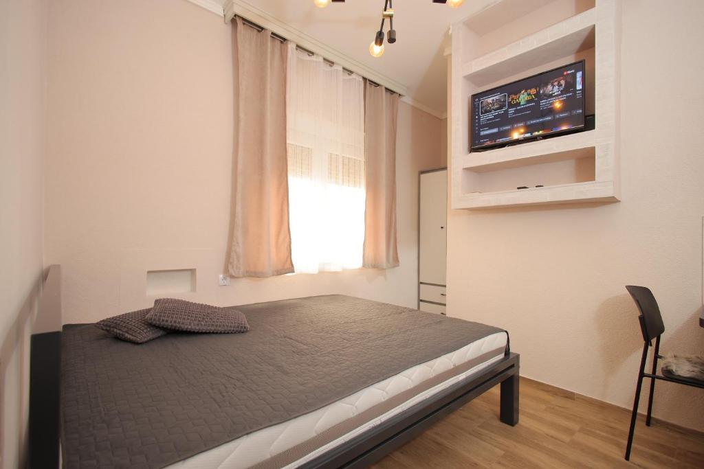 a bedroom with a bed with a television on the wall at Soho 1 in Vrnjačka Banja
