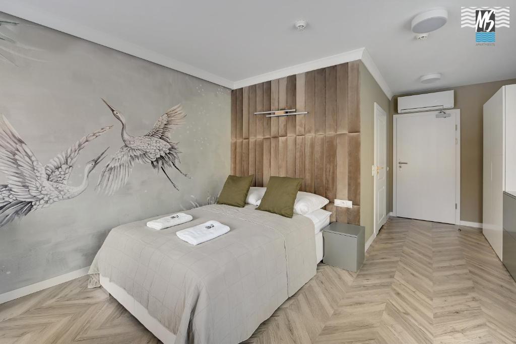 a bedroom with a bed and two birds on the wall at MS Apartments Rest 2.0 in Sopot