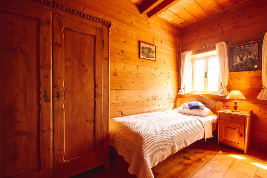 een slaapkamer met een bed in een houten hut bij Penzion Na Stodolci in Chřibská