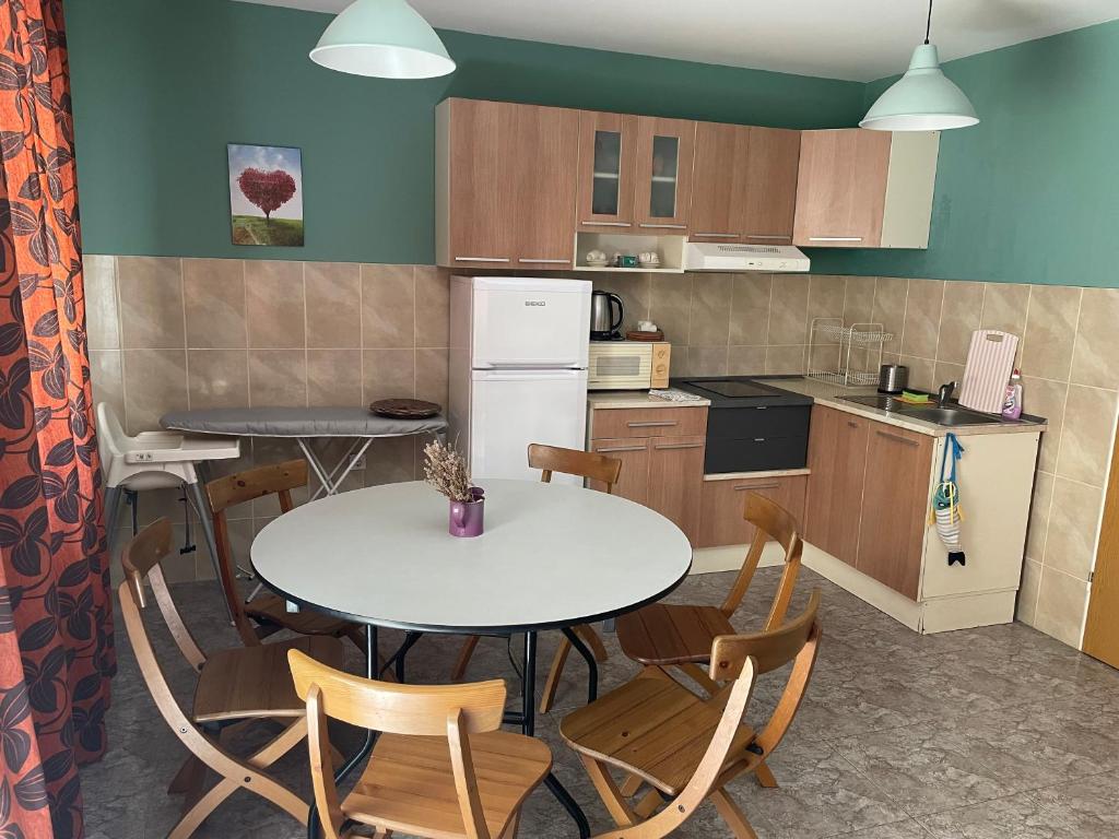 a kitchen with a table and chairs in a room at Comfort Apartment in Pomorie