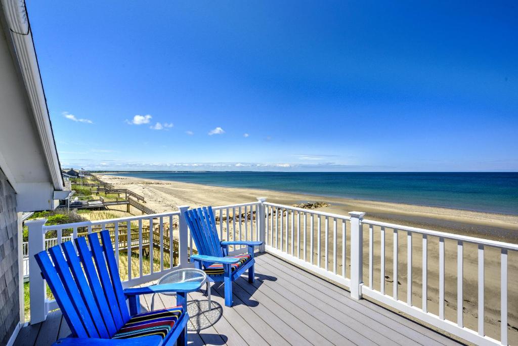 two blue chairs sitting on a porch looking at the beach at 69 Salt Marsh Road East Sandwich - Cape Cod in East Sandwich