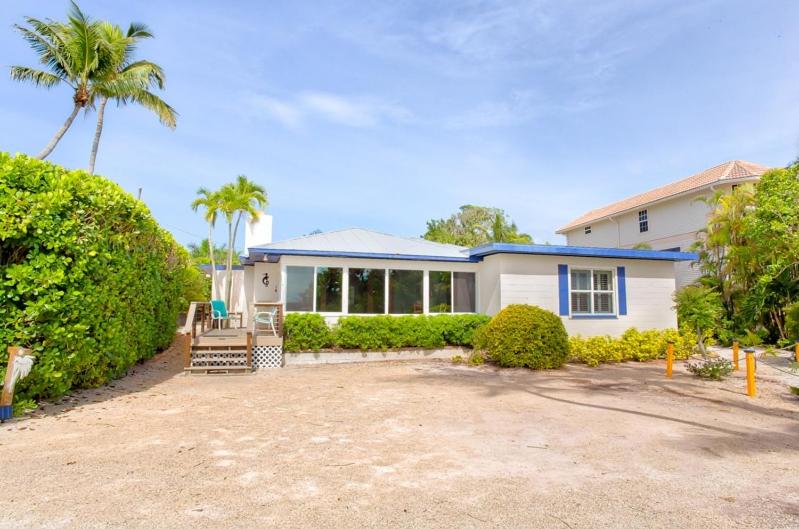 a white house with a palm tree in front of it at Baybarlyn home in Captiva