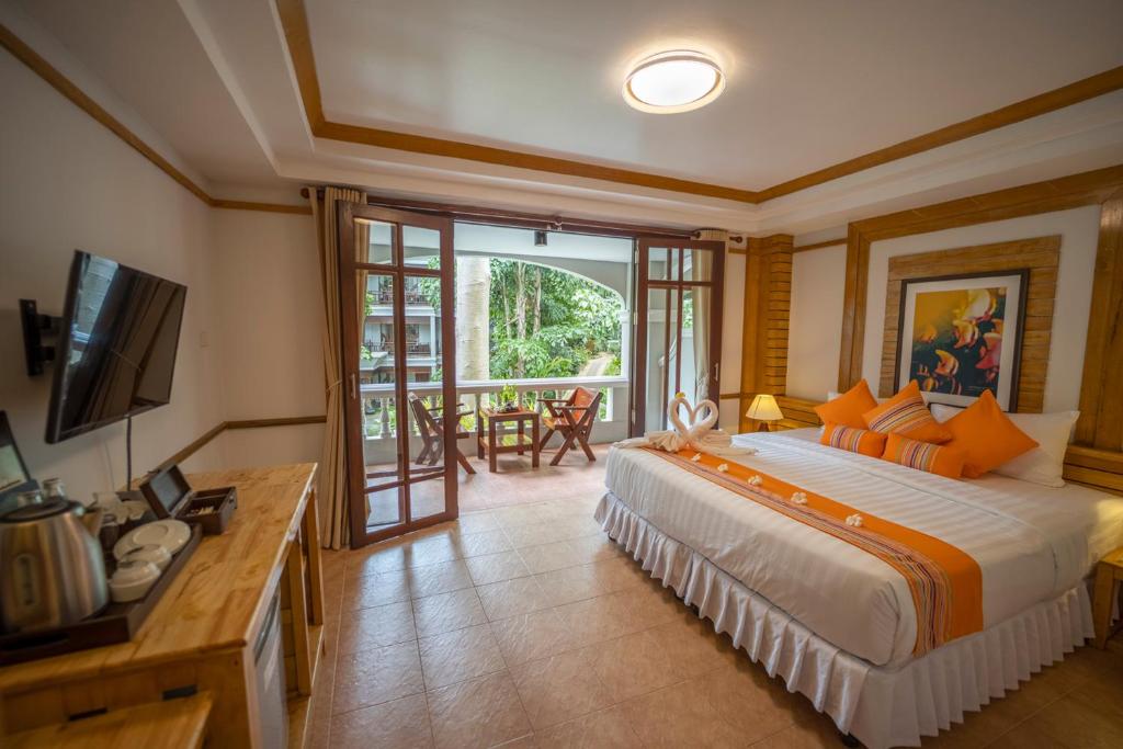 a bedroom with a large bed and a balcony at Ban's Diving Resort SHA Extra Plus in Ko Tao