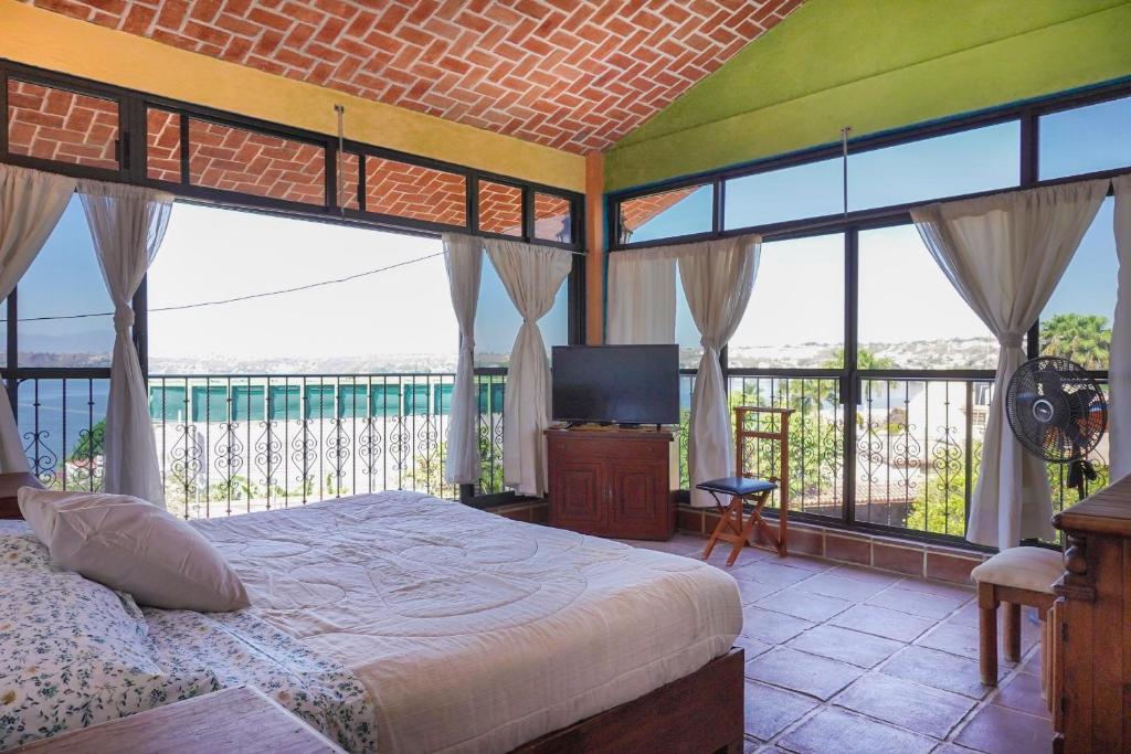 um quarto com uma cama e uma varanda com janelas em Casa Cayetana Teques em Tequesquitengo