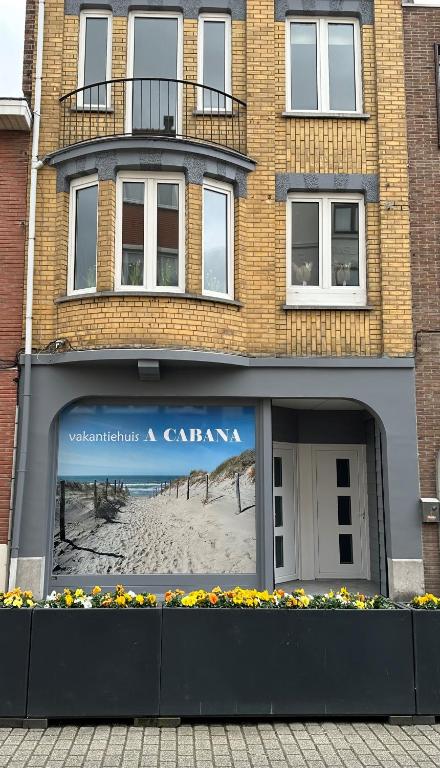 a building with a picture of a beach in the window at "A Cabana" in De Panne in De Panne
