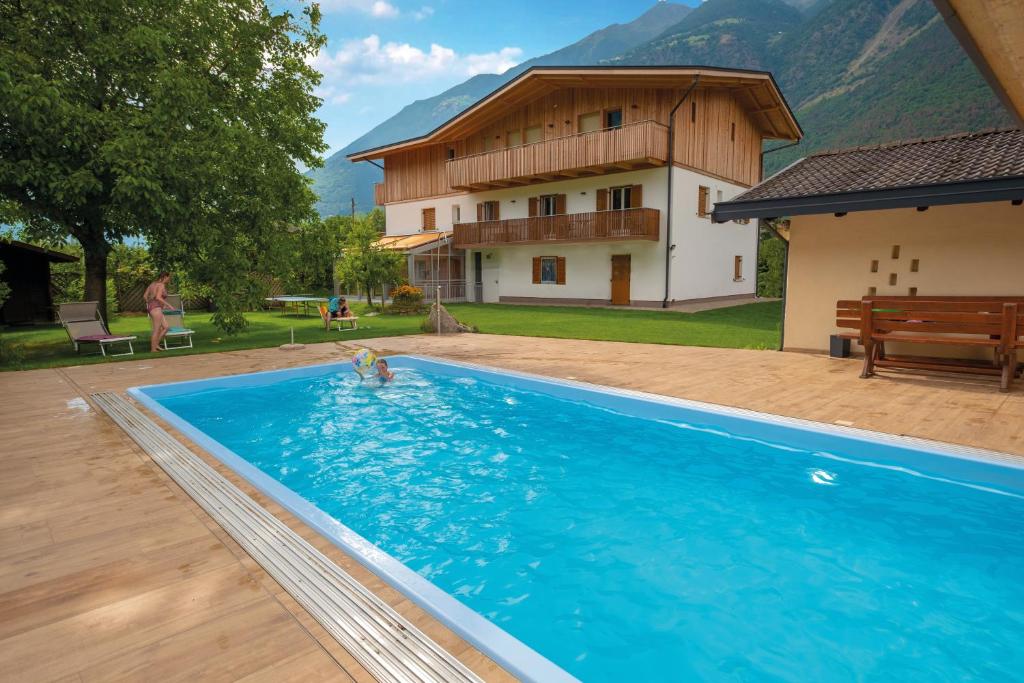 a person in a swimming pool in front of a house at Wiesenheim in Kastelbell-Tschars