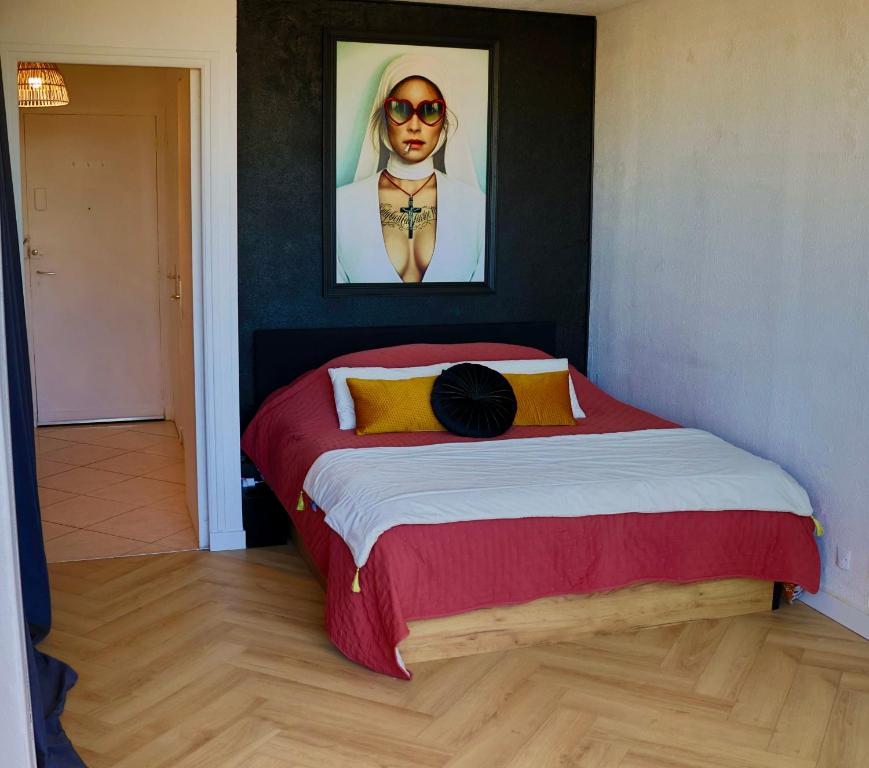 a bedroom with a bed with a picture of a woman at 'Cap Confession' - Naturiste - Sea View - Beach - Parking -Air Conditionaire in Cap d'Agde