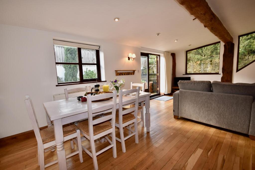 a kitchen and living room with a table and chairs at The Cote is a stunning rural barn beach 3 miles in Ryde