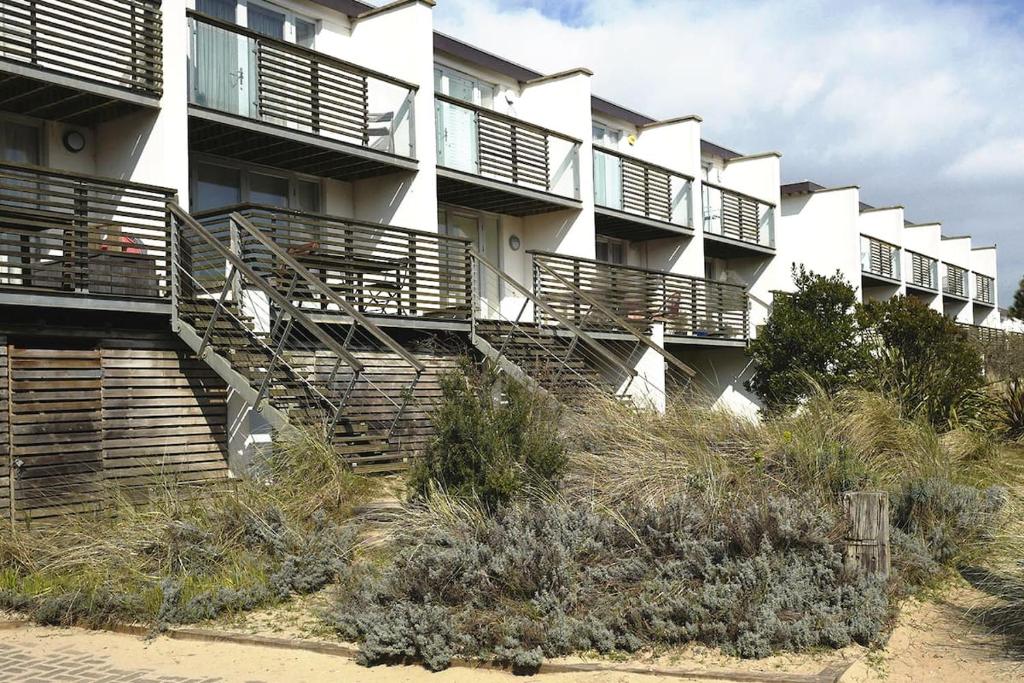 a building with stairs in front of it at Wild Sands Next to Beach ✩ Cinema ✩ Living Roof ✩ Games Room in Camber