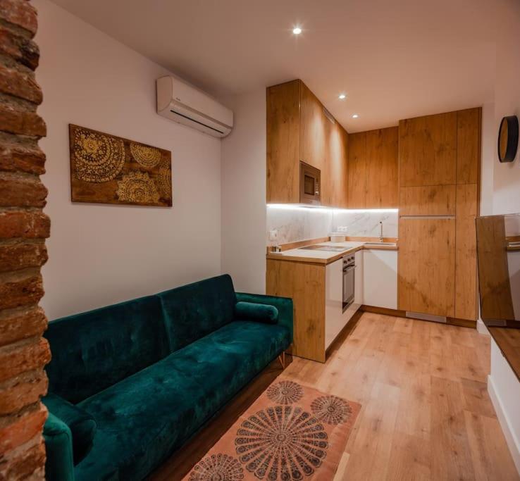 a living room with a green couch in a kitchen at Luxury flat Salamanca V in Madrid