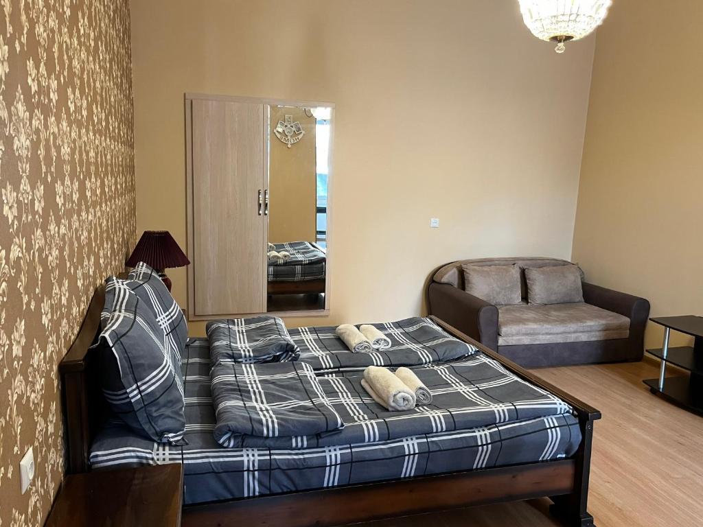um quarto com uma cama, uma cadeira e um espelho em Sunny Apartments em Tbilisi