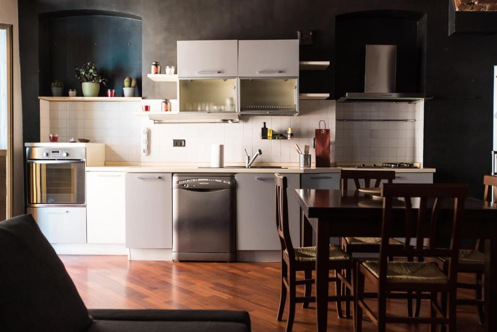 cocina con armarios blancos, mesa y sillas en Orpheus Apartment, en Turín