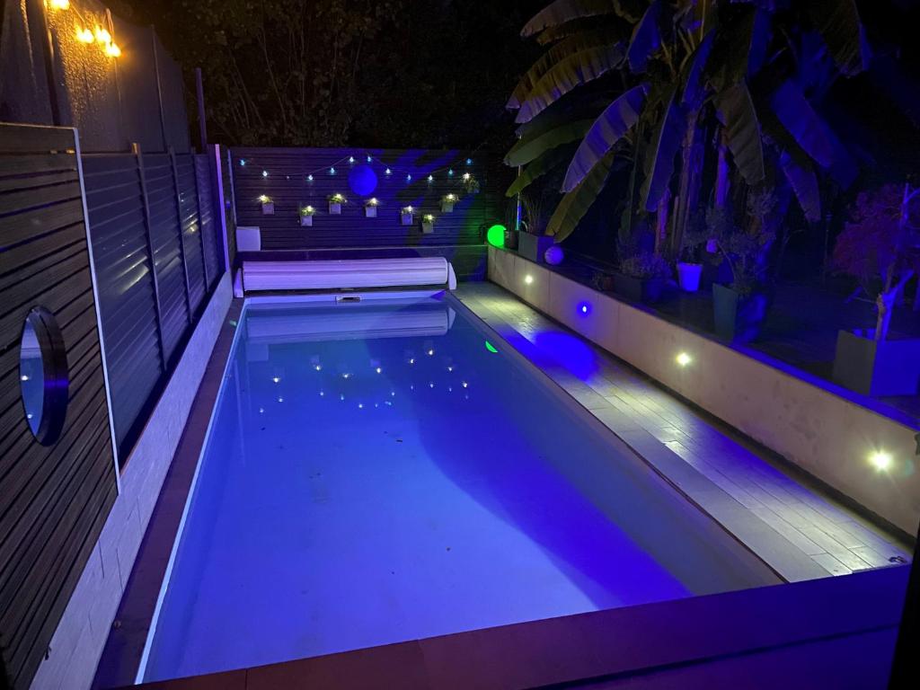 una piscina iluminada por la noche con luces en L'Eden, en Saint-Rémy-lès-Chevreuse