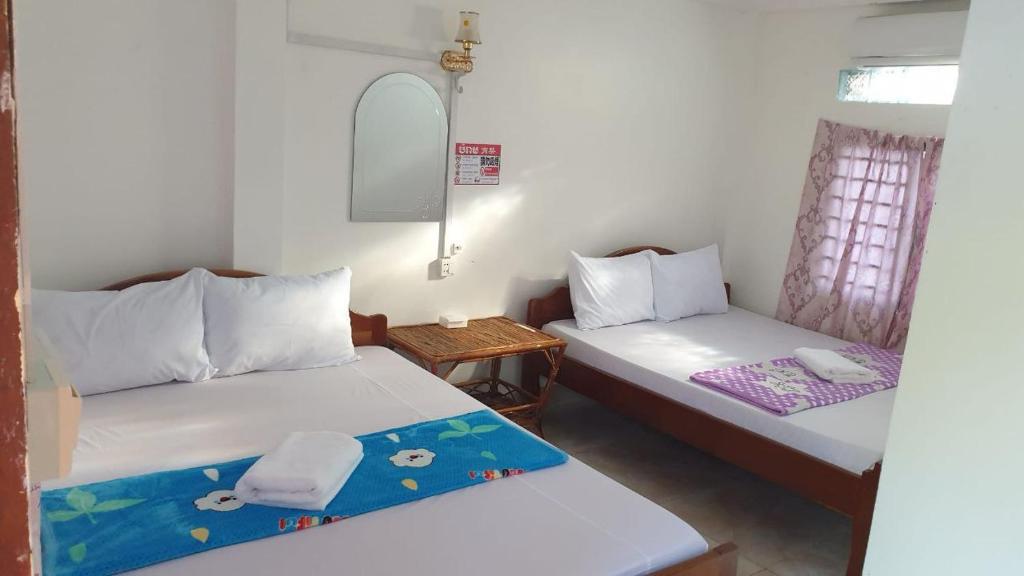a room with two beds and a small table at Oun Guesthouse in Koh Rong Island