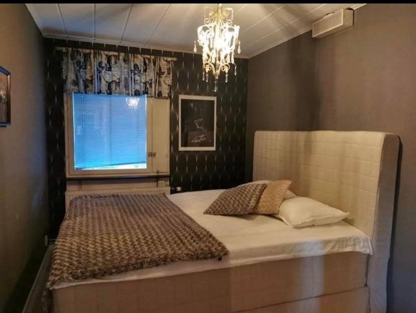 a bedroom with a large bed and a window at Own private room in a big house! in Luleå