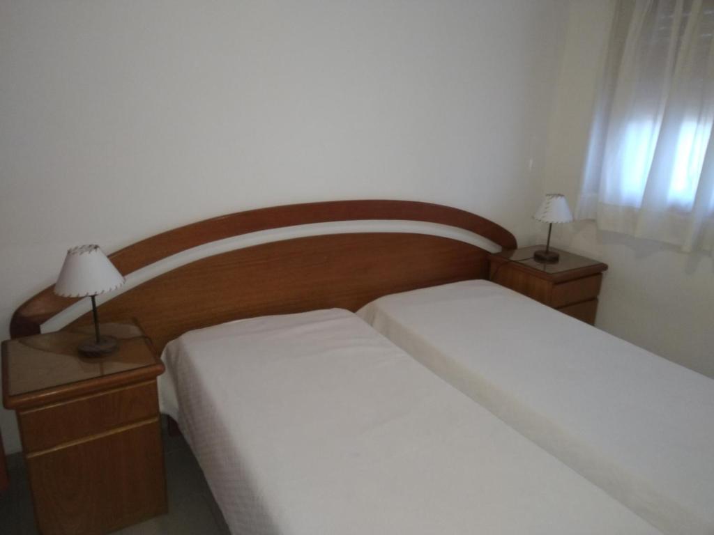 a small bedroom with two beds and two lamps at Gracyal in Chascomús
