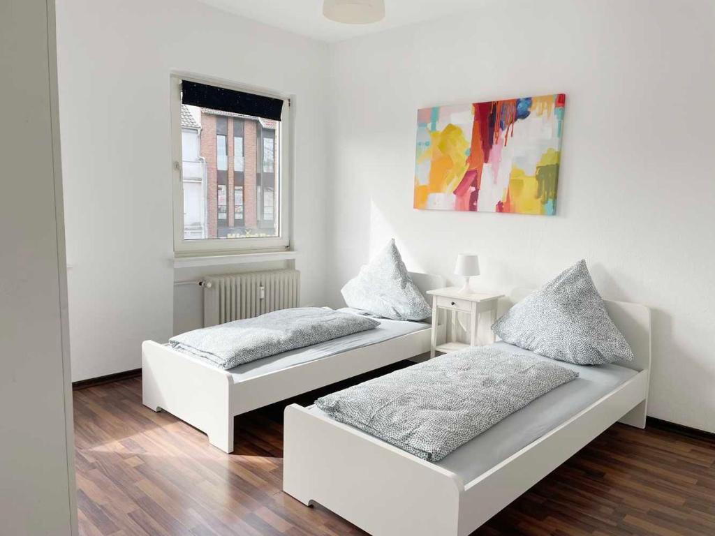 2 bedden in een witte kamer met een raam bij Apartment with 3 rooms in Hürth in Hürth