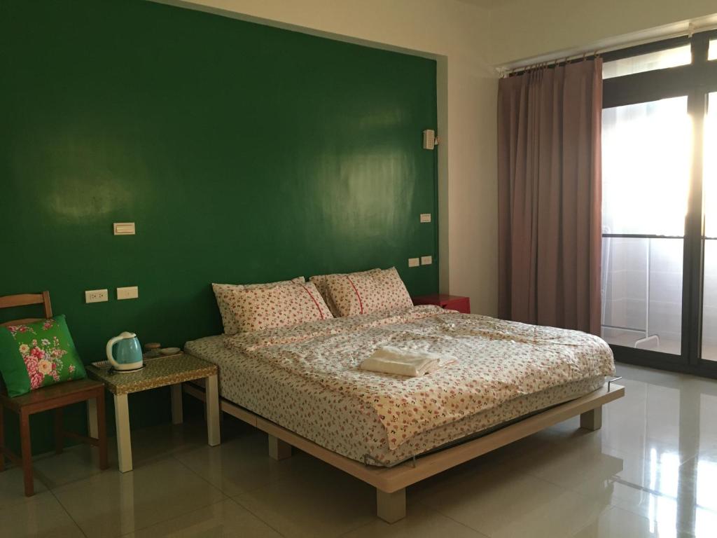 宜蘭市にある東津左岸民宿の緑の壁のベッドルーム1室、ベッド1台が備わります。