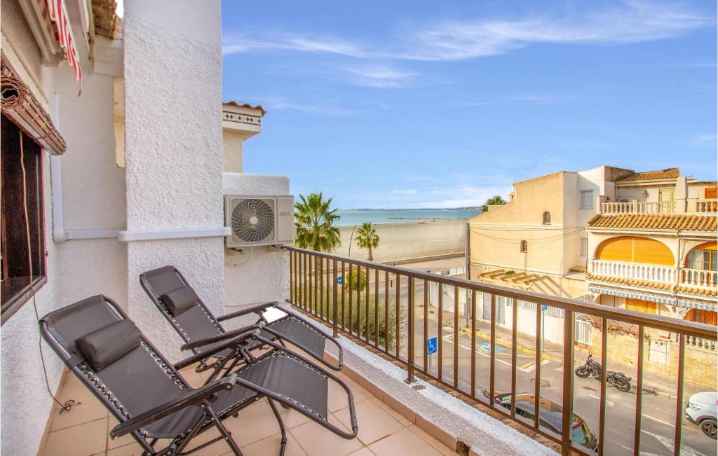 a balcony with two chairs and a view of the ocean at Pet Friendly Home In Santa Pola With Kitchenette in Santa Pola
