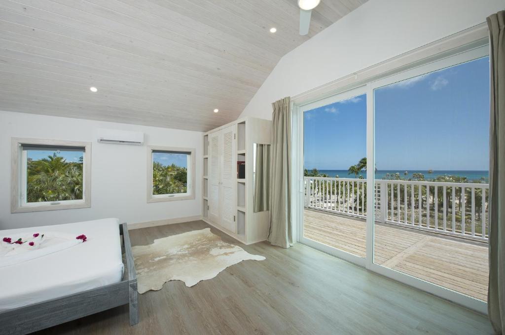 Großes weißes Zimmer mit einem Billardtisch und einem Balkon. in der Unterkunft See Sea home in Governors Harbour