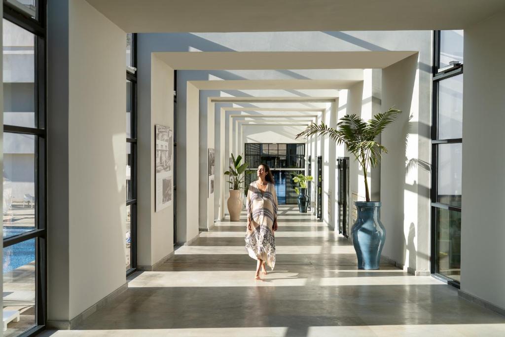 una mujer caminando por un pasillo en un edificio en Vichy Thermalia Spa Hôtel, en Fez