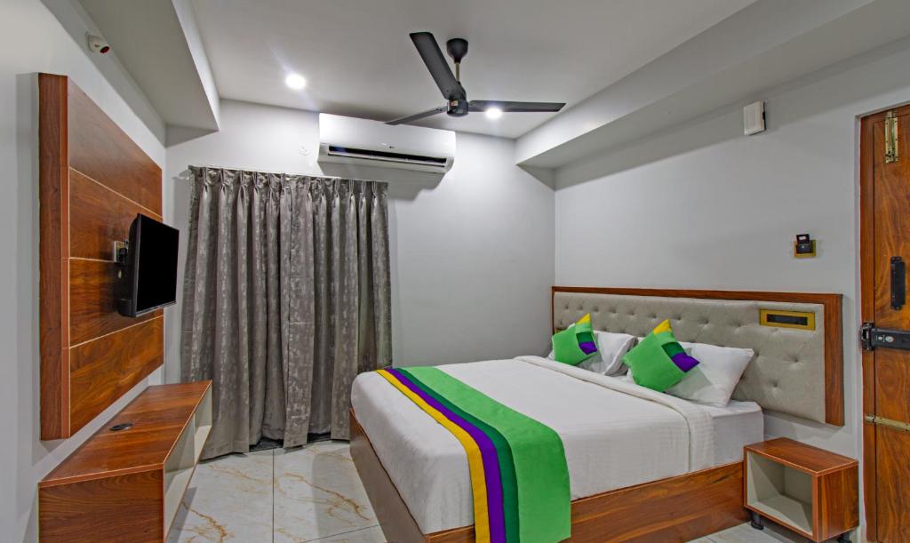 a bedroom with a bed and a television in it at Treebo Trend Abhi Suites, Guntur in Guntūr