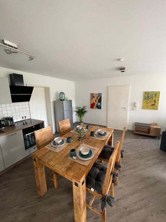 een keuken met een houten tafel en stoelen in een kamer bij Wohnung Rhein-Wald-und Weitsicht in Rengsdorf