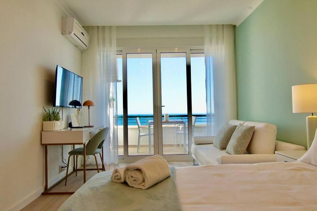 ein Schlafzimmer mit einem Bett und ein Wohnzimmer mit einem Schreibtisch in der Unterkunft Sea Lovers - Sea front - studio apartment in Monte Gordo