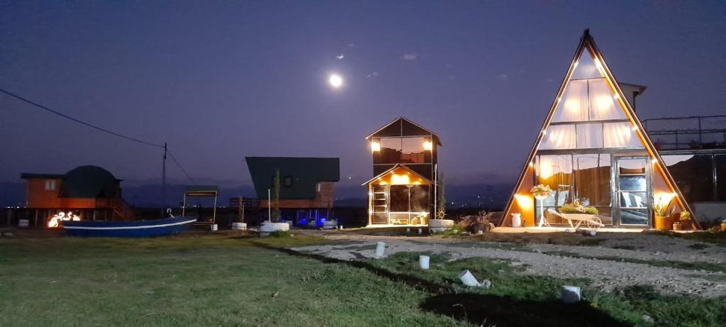 a large glass house with a pyramid roof at night at Glamping y Cabañas el Encanto los Lirios in Tota