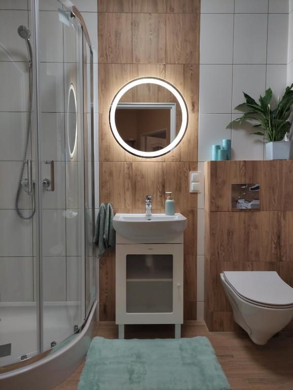 a bathroom with a sink and a shower and a toilet at Apartament Jagiełły 14 in Giżycko