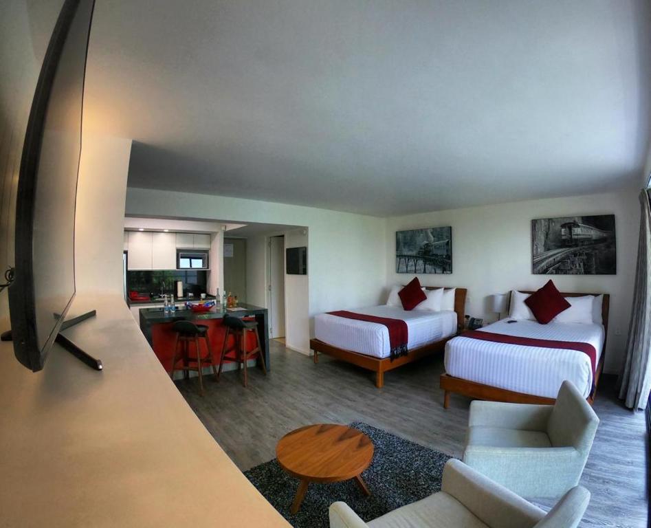 a hotel room with two beds and a kitchen at Armonik Suites in Mexico City