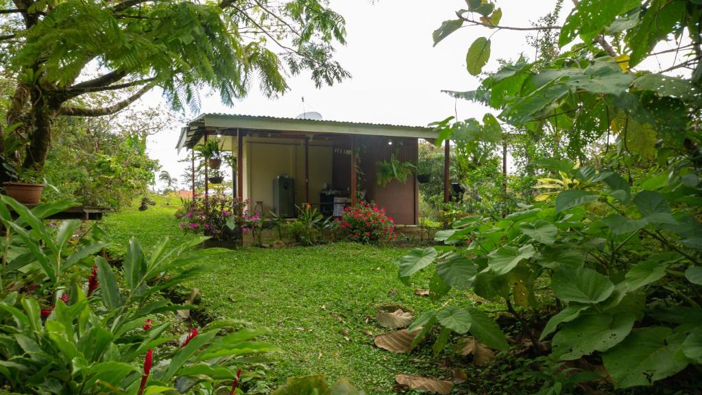 una pequeña casa en medio de un jardín en Casita Rivera Río Celeste en Bijagua