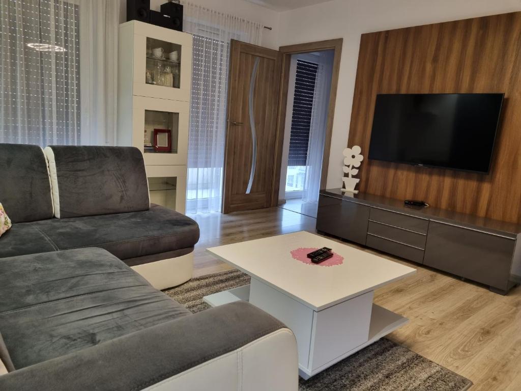 ein Wohnzimmer mit einem Sofa und einem Tisch in der Unterkunft Apartament na obrzeżach Kalisza in Kościelna Wieś
