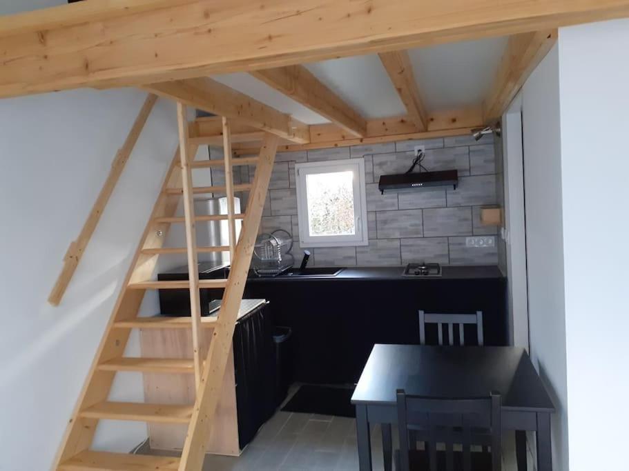 a kitchen with a staircase leading up to a loft at Logement entier: Un air d' évasion à Saint Pardon in Vayres