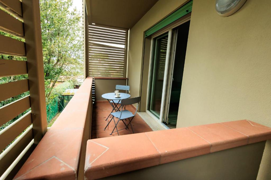 a small balcony with a table and a window at Residence San Francesco in Tirrenia