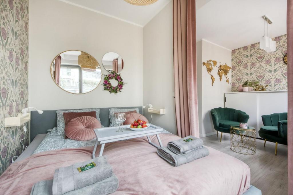 a small bedroom with a pink bed and a table at City Flower Apartment in Warsaw