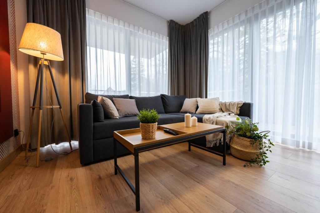 sala de estar con sofá y mesa en Apartamenty Pod Gondolą - Mountain Resort Villa z sauną - Dream Apart en Szczyrk