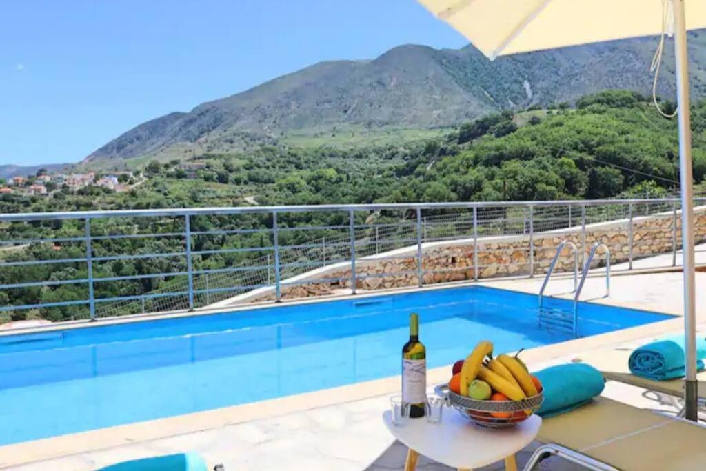 - une piscine avec une table et une bouteille de vin dans l'établissement Villa Veneciana with Heated Pool, à Kástellos