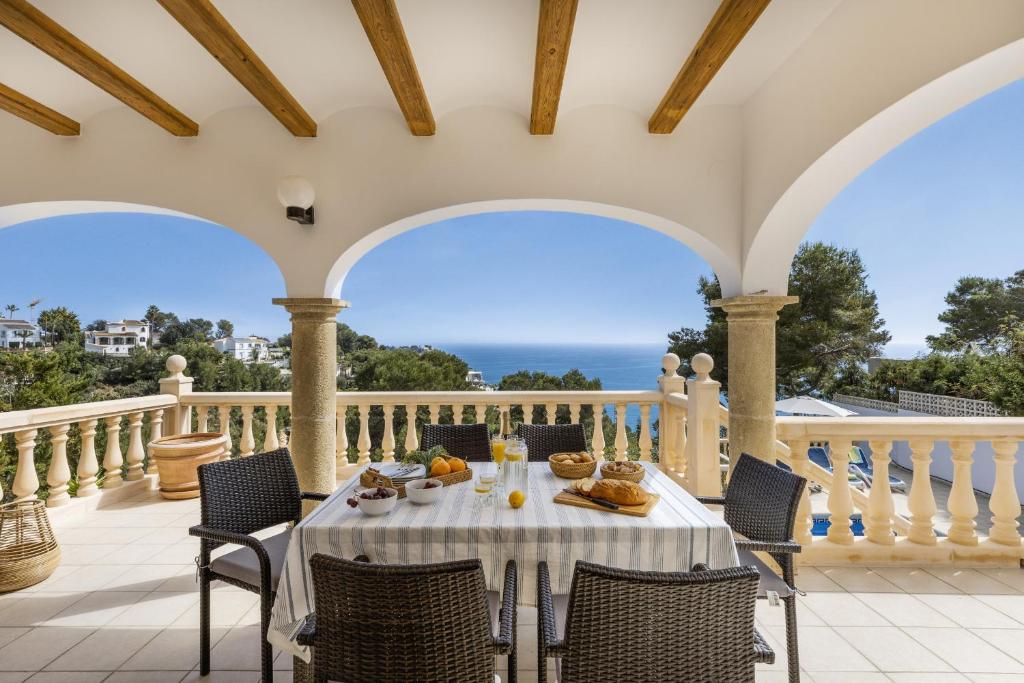 a table on a balcony with a view of the ocean at Casa Thalassa in Balcon del Mar