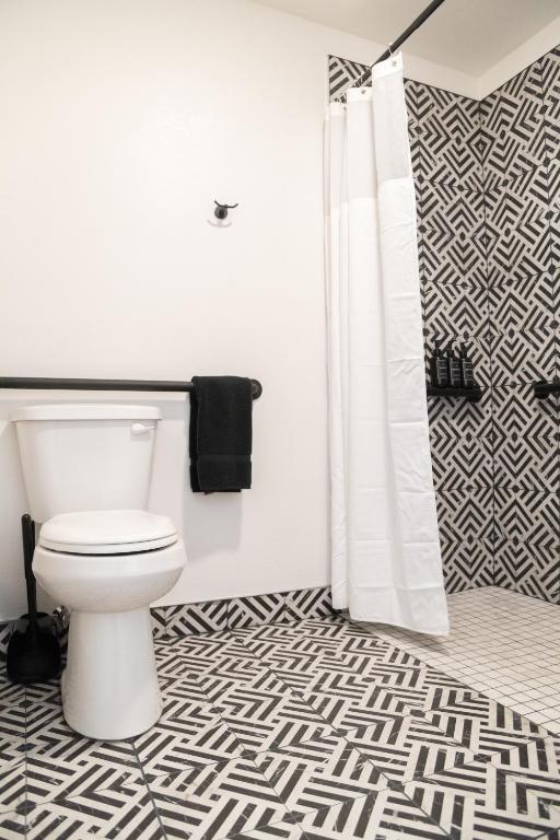 a bathroom with a toilet and a shower curtain at High Creek Lodge and Cabins in Pagosa Springs