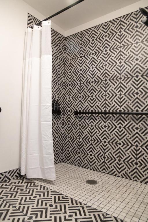 a bathroom with a shower curtain and a geometric tile wall at High Creek Lodge and Cabins in Pagosa Springs