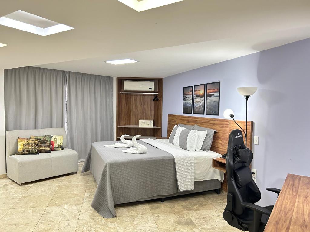 a bedroom with a bed and a desk and a chair at Belavista Hotel in Itaberaba